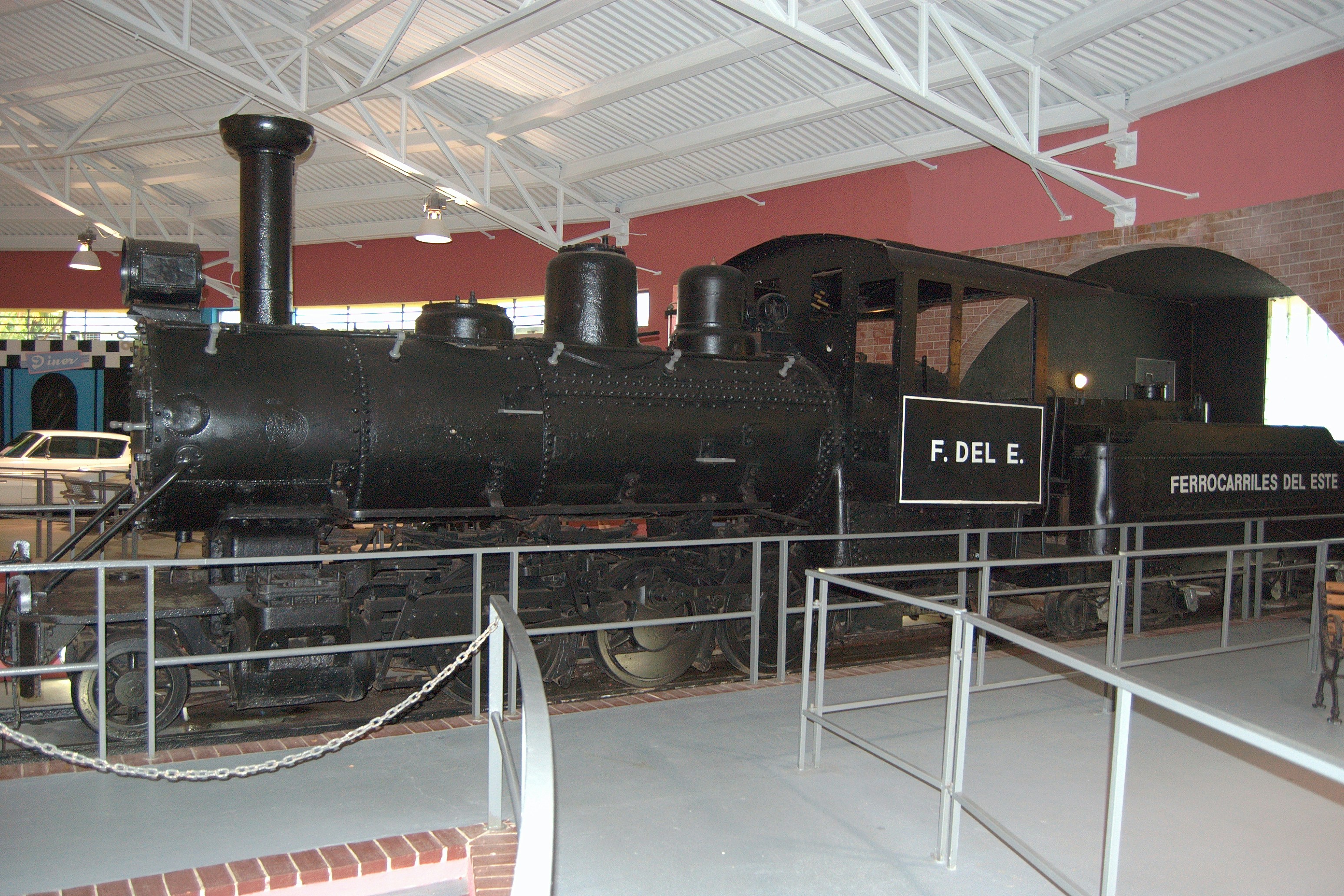 Ornate antique steam locomotive with brass fittings and decorative panels, warm amber interior lighting, museum display setting