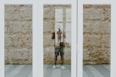 person near white framed glass door close-up photography
