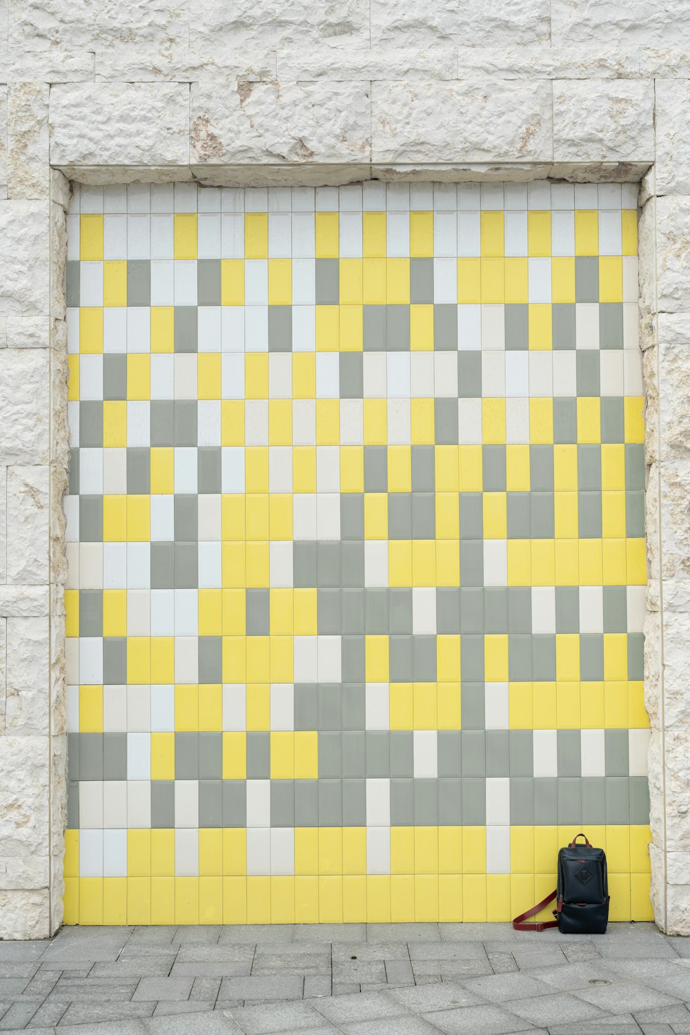 black backpack in yellow, white and grey wall