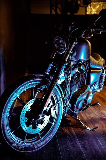 A sleek motorcycle parked in a sunlit garage, showcasing shiny chrome details.