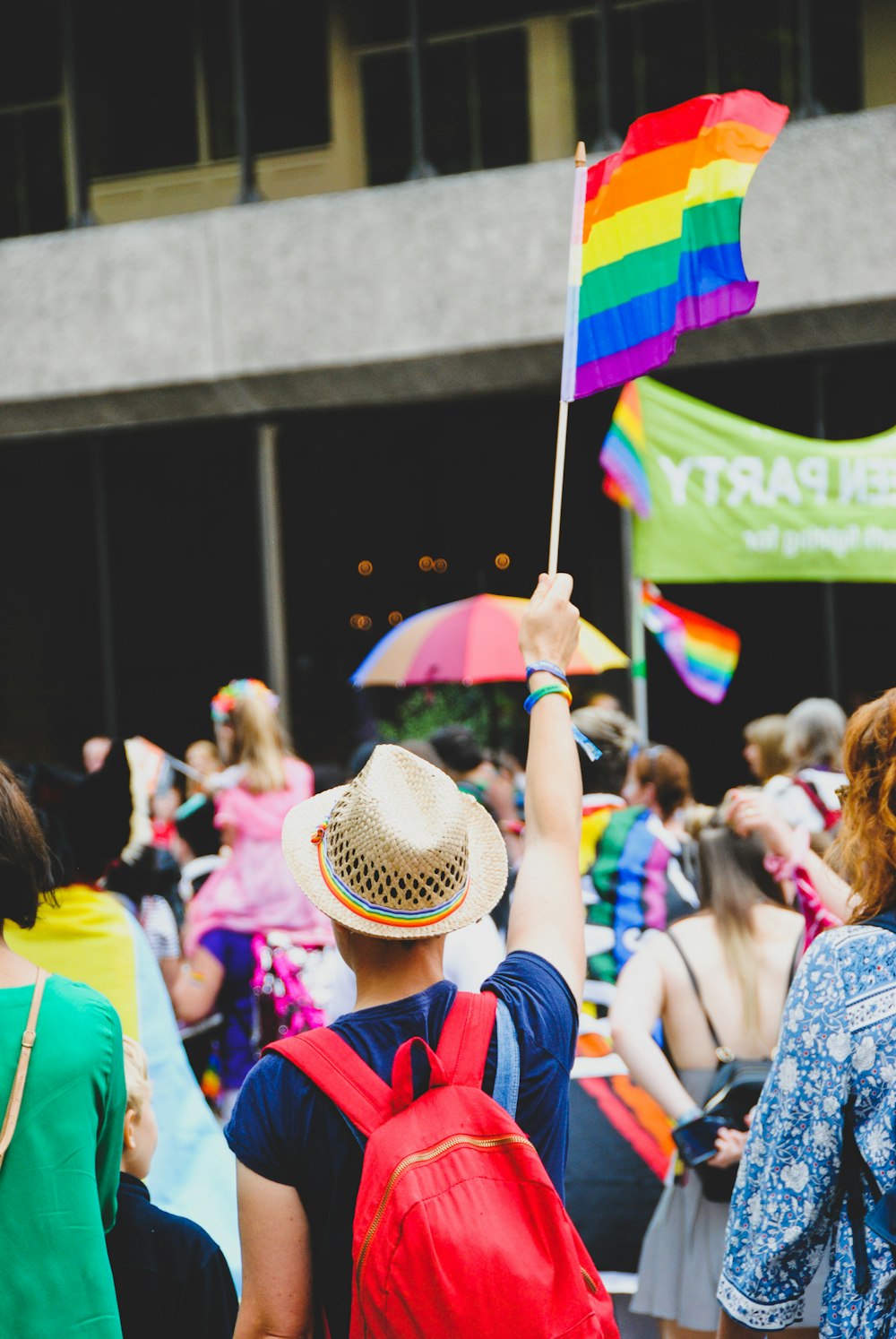 man raising multi-colored flaglet