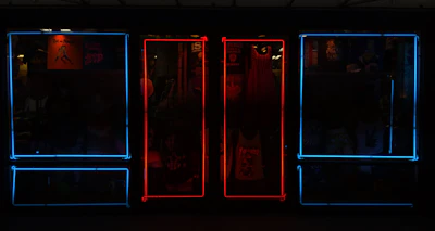 Display of trendy K-pop merchandise including shirts, posters, and accessories under neon lights.