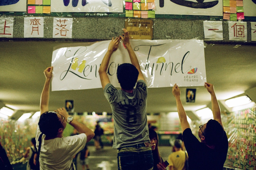 three men putting signage