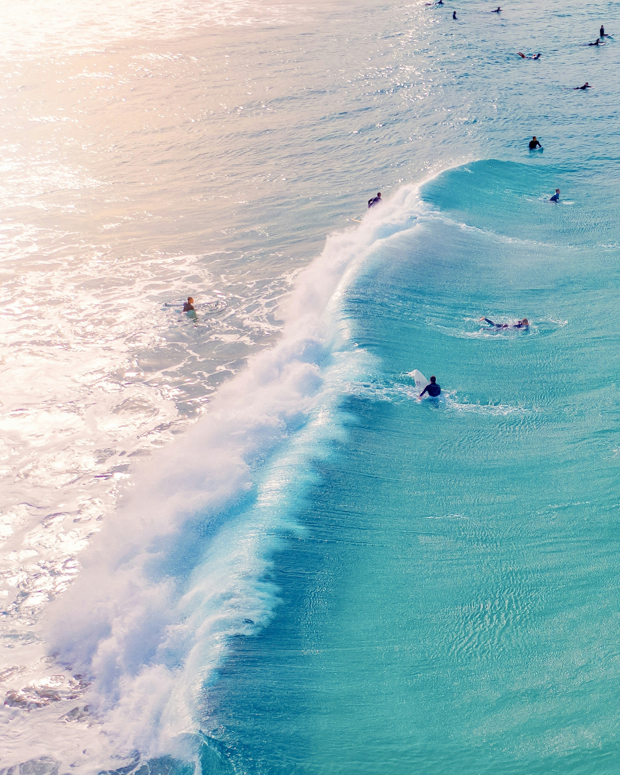 group of people doing surfing on body of water during daytime