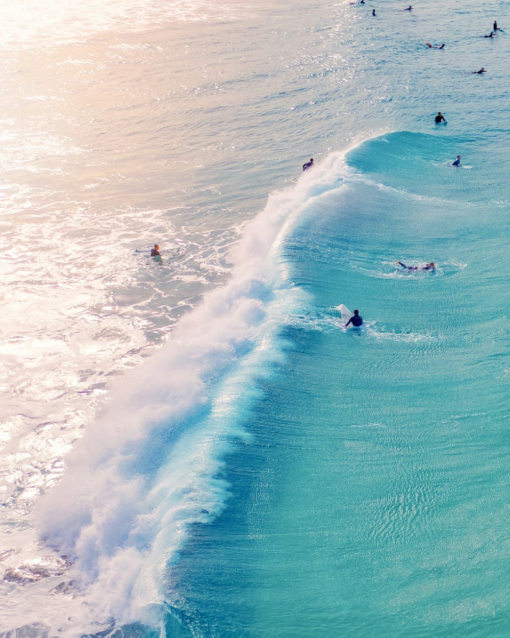 group of people doing surfing on body of water during daytime