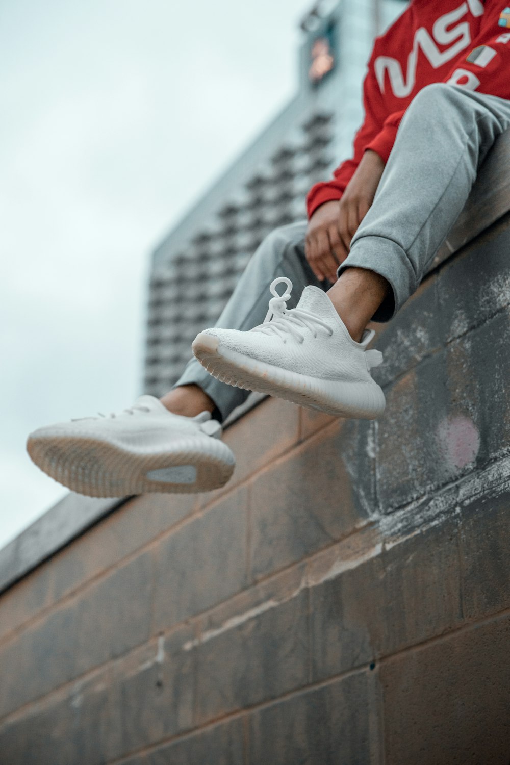 a man sitting on top of a brick wall