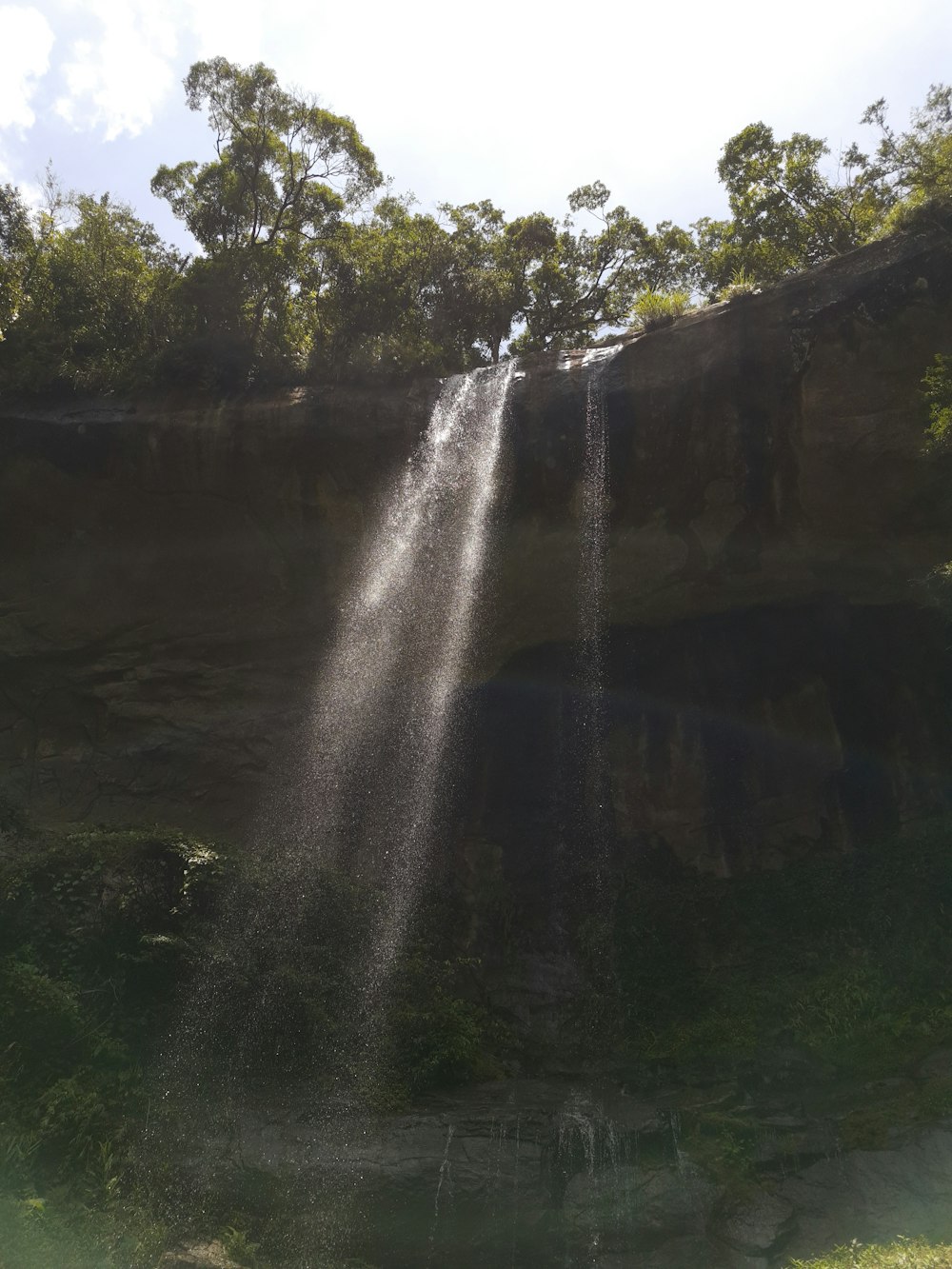 a large waterfall falling down into a body of water