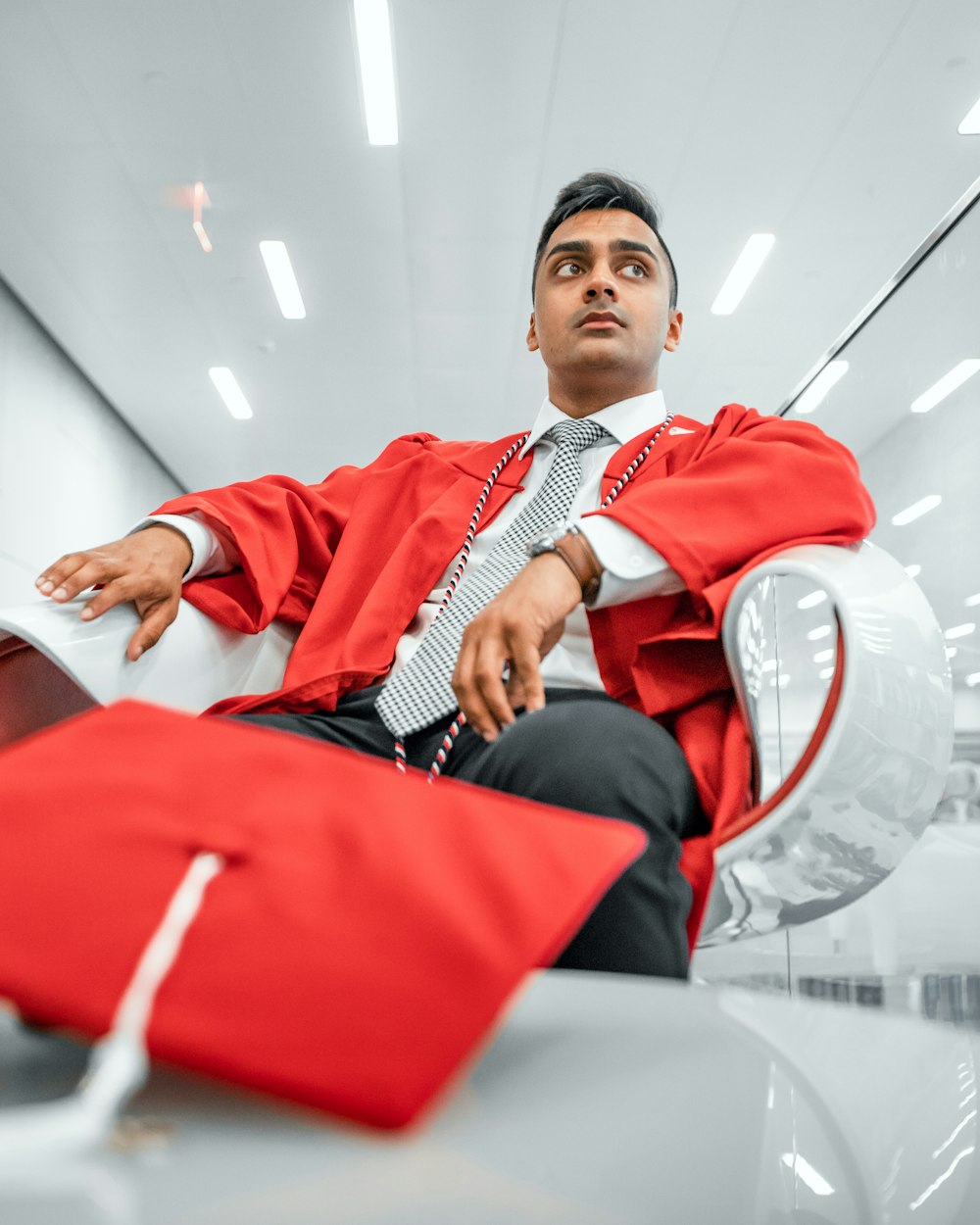 a man in a red robe sitting in a chair