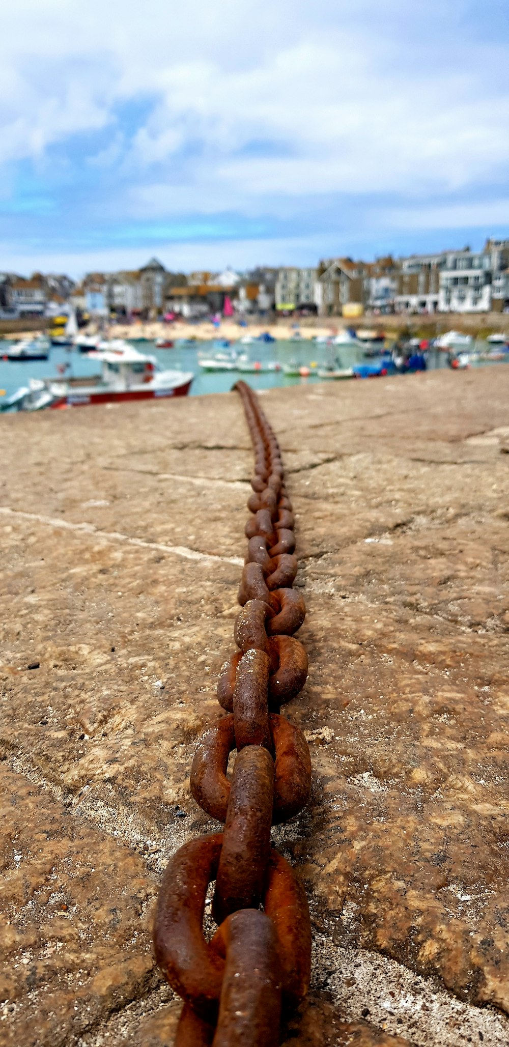 Una larga cadena de cadenas oxidadas sobre una superficie de hormigón