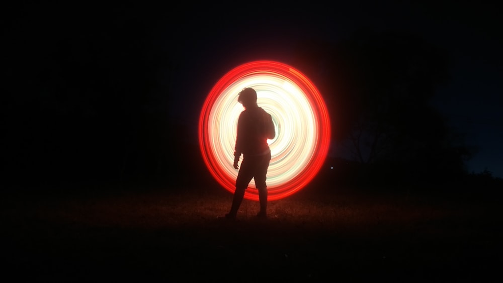 silhouette d’homme avec le feu pendant le temps de nuit