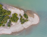 Aerial view of a small island with white sandy beaches and crystal-clear water.