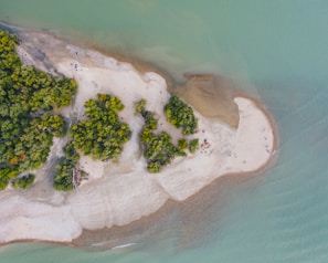 Aerial view of a small island with white sandy beaches and crystal-clear water.