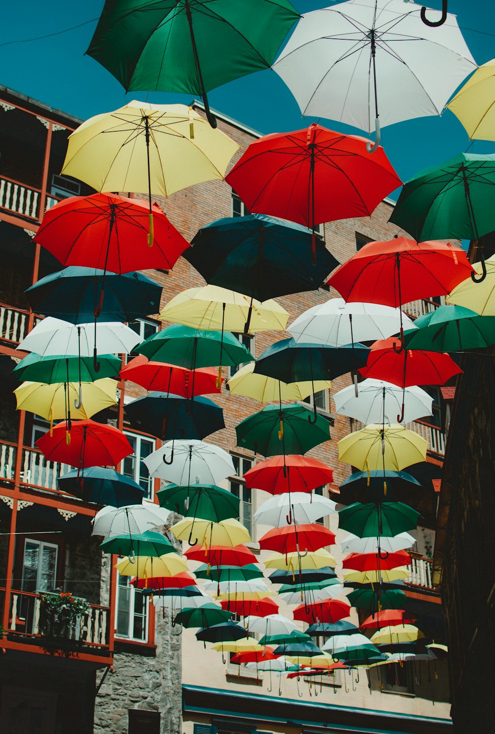 a bunch of umbrellas that are hanging in the air