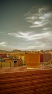 A colorful patterned flask sitting on a rocky ledge overlooking a mountain valley.