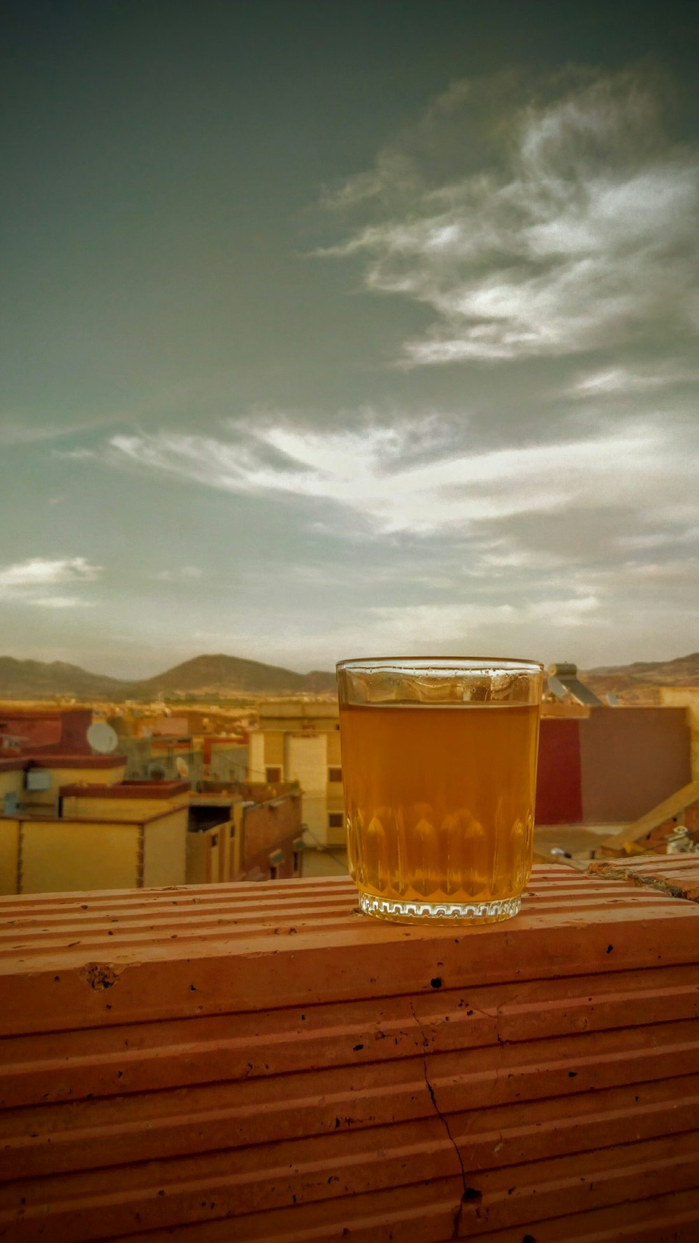 clear pint glass with beer on ledge