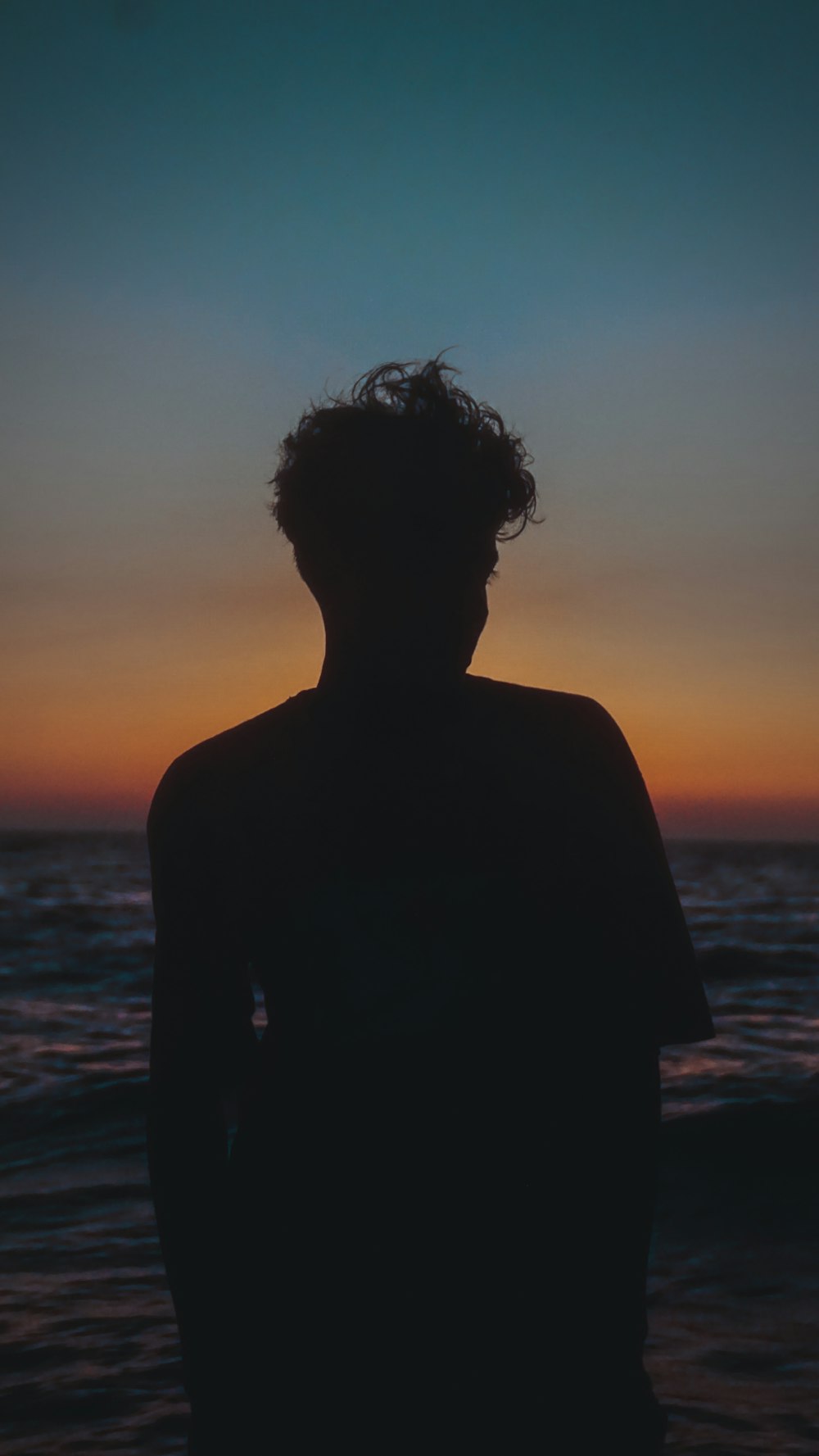 a person standing in front of a body of water