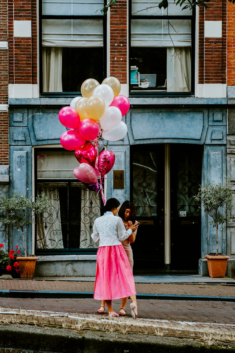 woman holding bunch of party balloons at the street