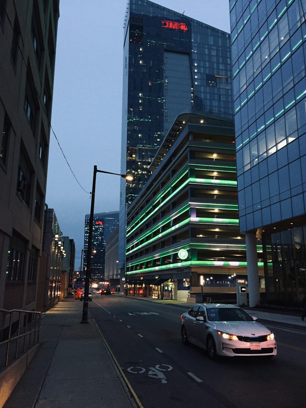 a car driving down a street next to tall buildings
