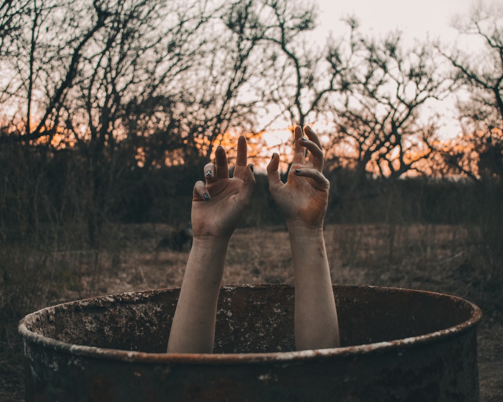 a person with their hands up in a barrel