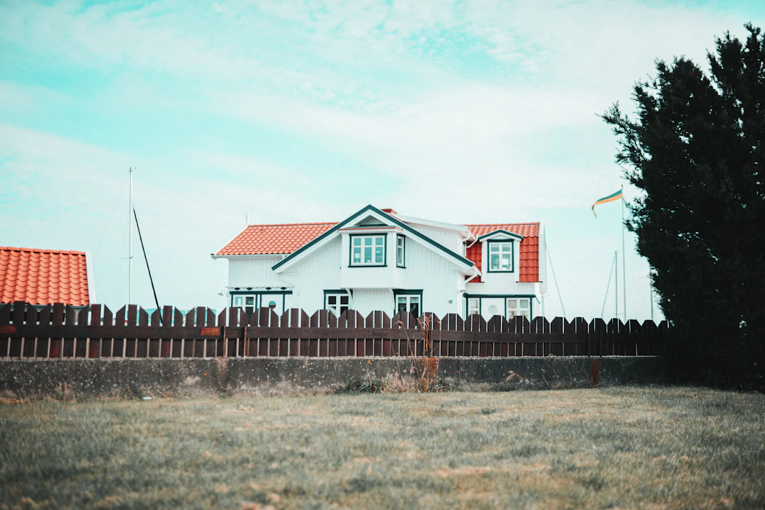 House roofline seen over a long wood privacy fence