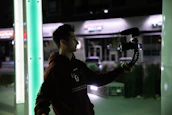 A happy vlogger using a Voices of Change microphone outdoors.