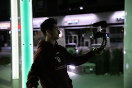 A happy vlogger using a Voices of Change microphone outdoors.