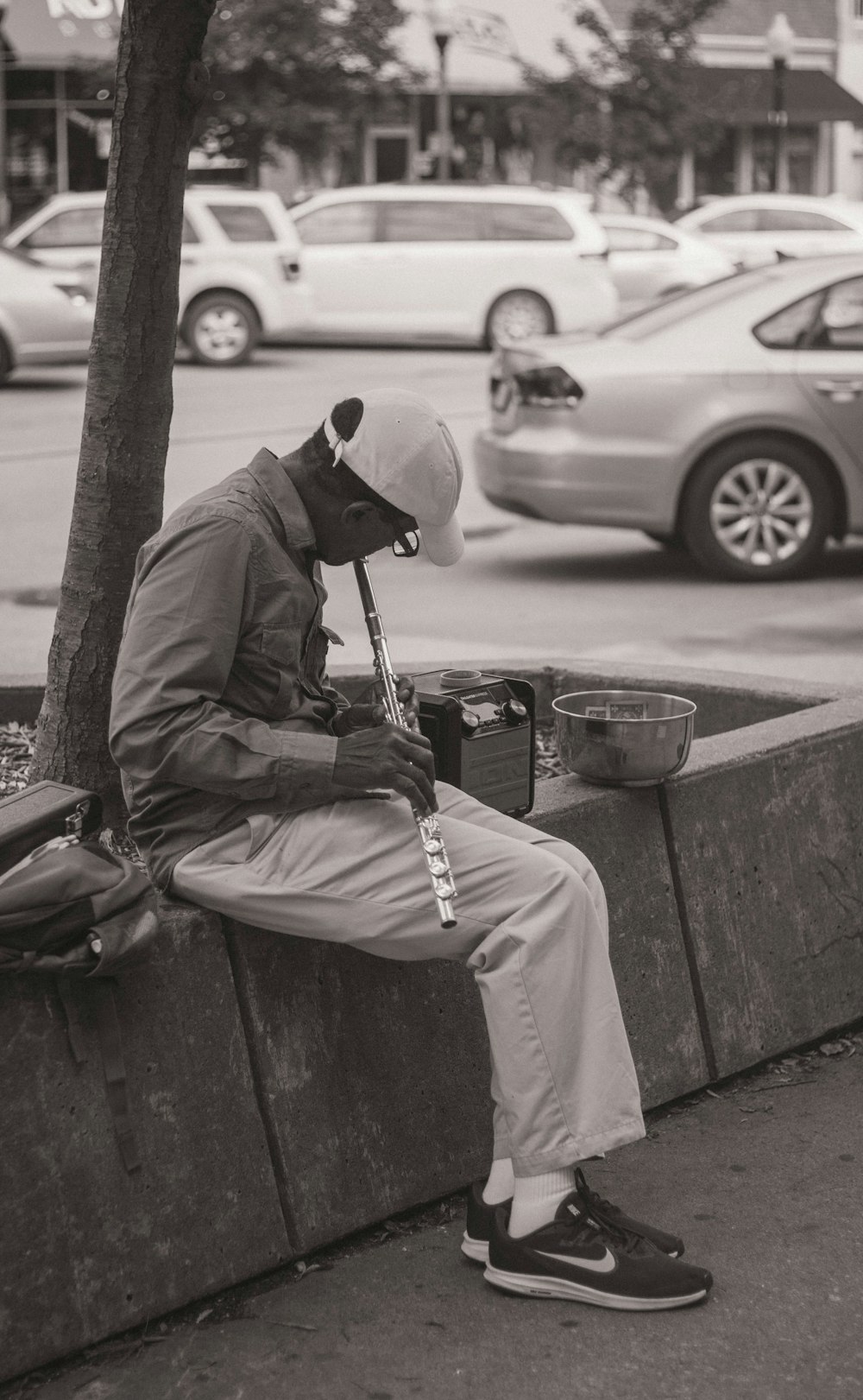 grayscale photography of man playing flute