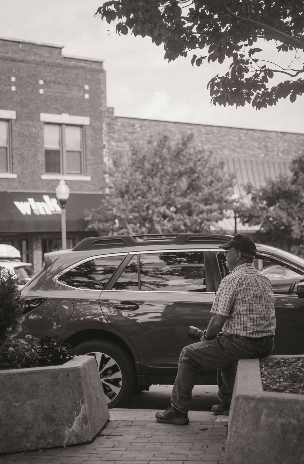 grayscale photography of man siting