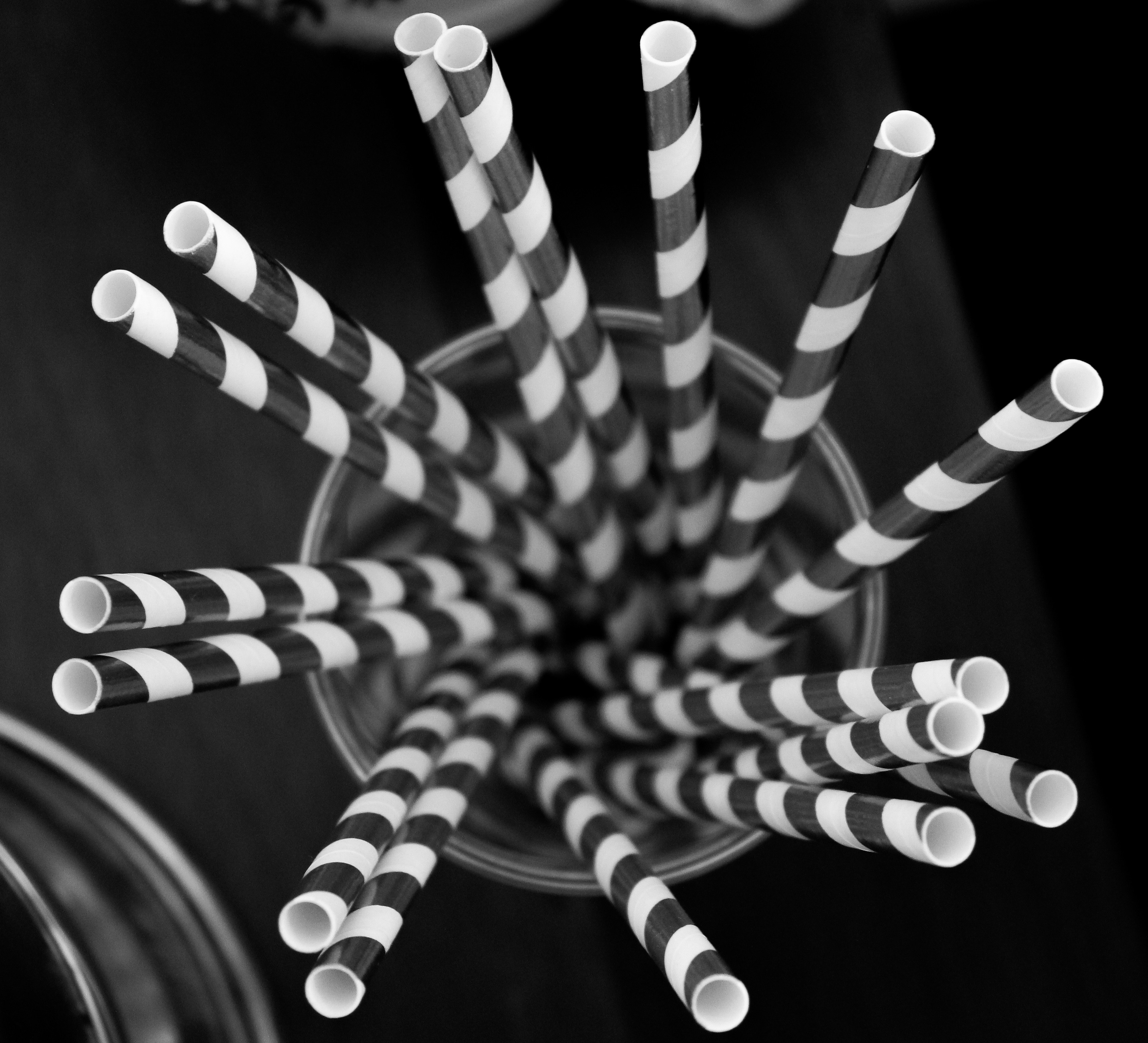 a bunch of black and white striped straws in a glass