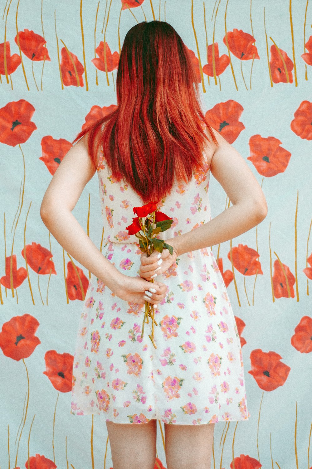 woman hides red roses from her back