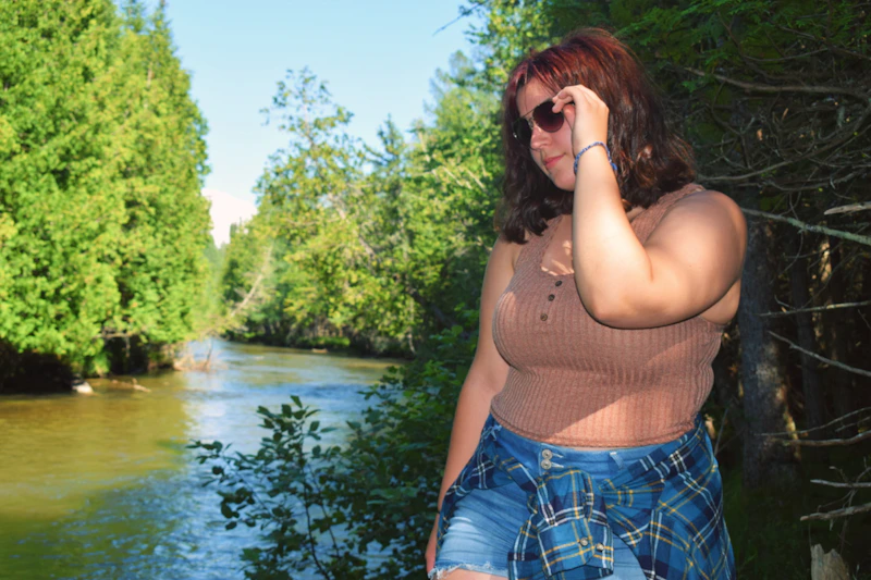 BBW woman enjoying nature near a river in the forest