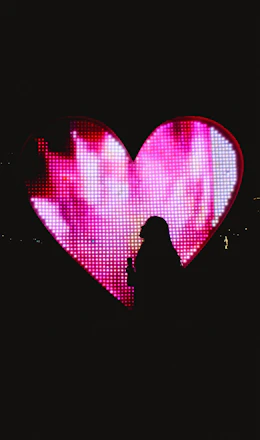 A glowing heart-shaped counter displaying the total donations raised, surrounded by warm light.