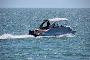 Motorboat engine being cleaned and maintained on a sunny day near the water