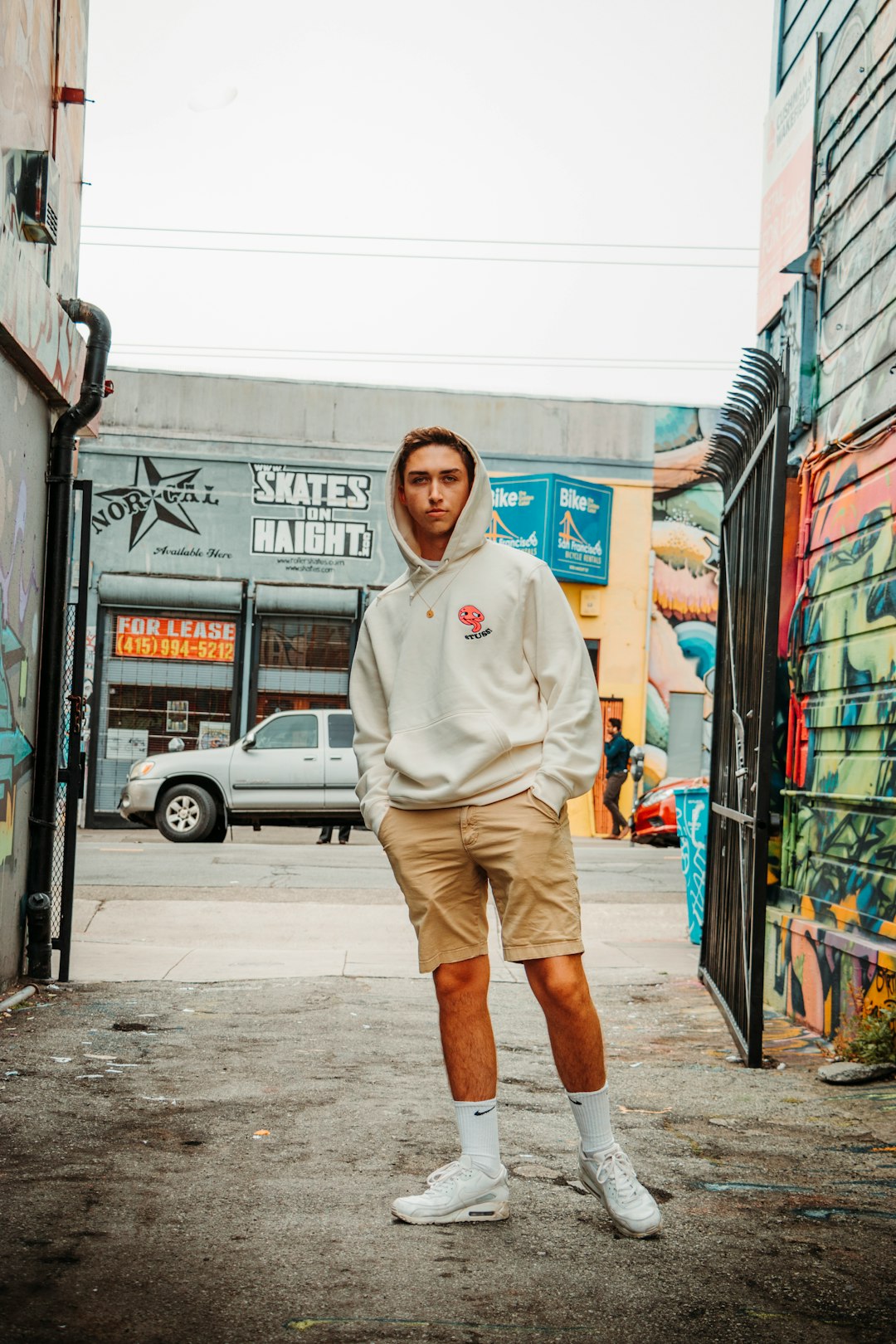 man wearing hooded jacket standing near road