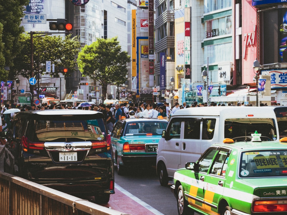 green sedan at road beside white van