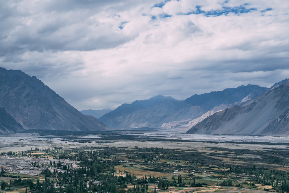 a scenic view of a valley with mountains in the background