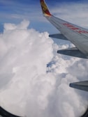 A plane wing above clouds symbolizing smart and accessible travel solutions.