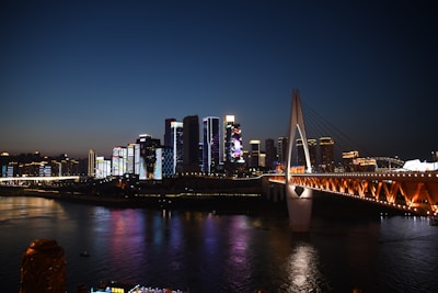 Nighttime shot of a city skyline featuring elisdons' illuminated bridge project, highlighting modern design and community connection.