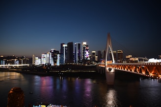 Nighttime shot of a city skyline featuring elisdons' illuminated bridge project, highlighting modern design and community connection.