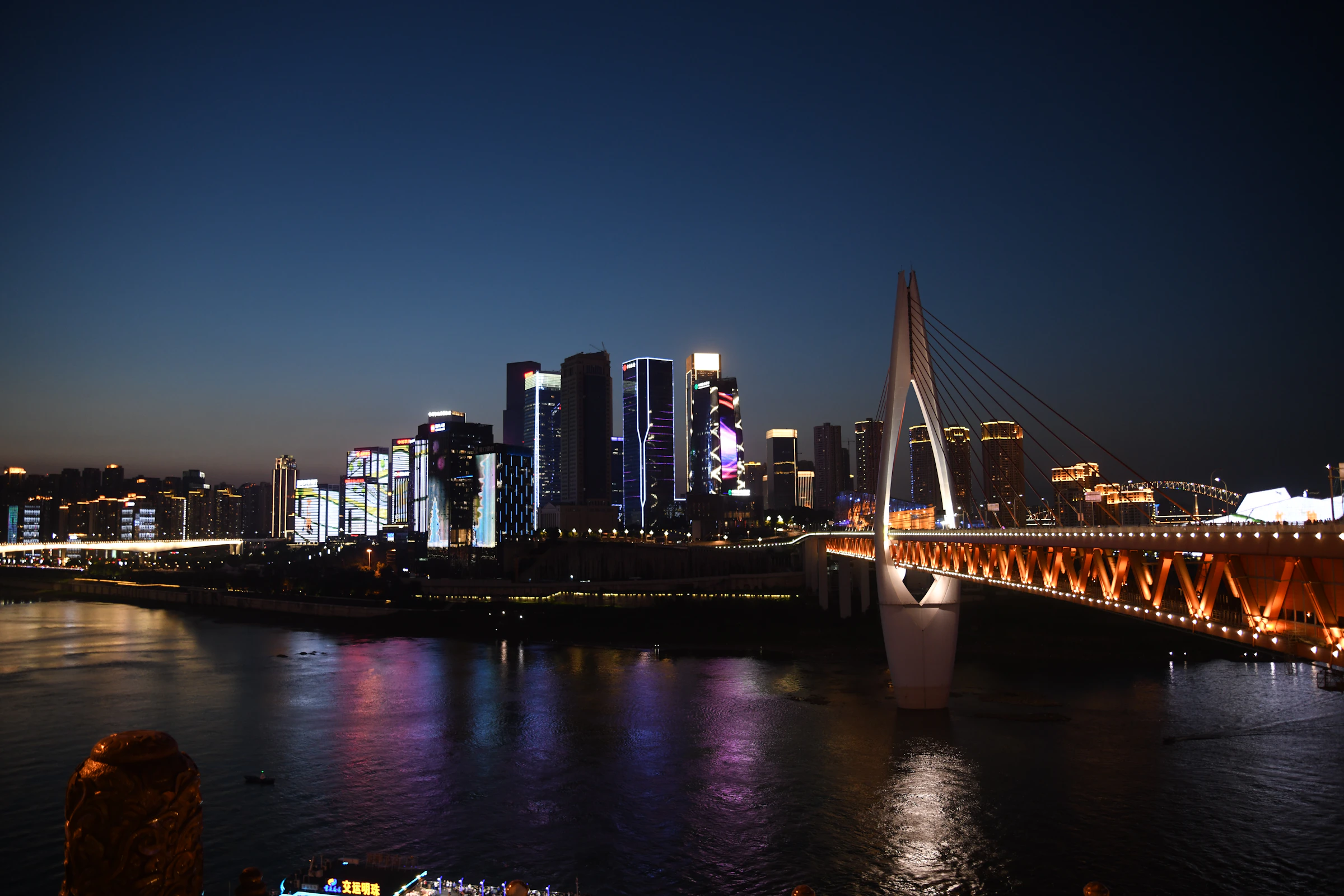 Hongya Cave night skyline glowing above the Jialing River in Chongqing