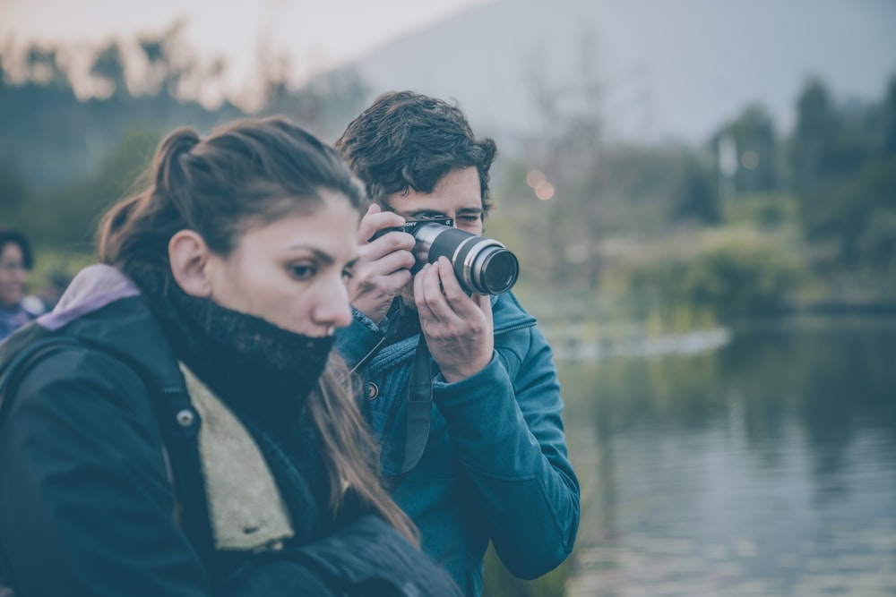 man and woman beside body of water