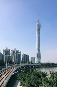 a very tall tower towering over a city next to a river