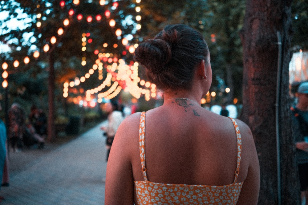 backview of woman wearing dress and with tattoo on back of her neck