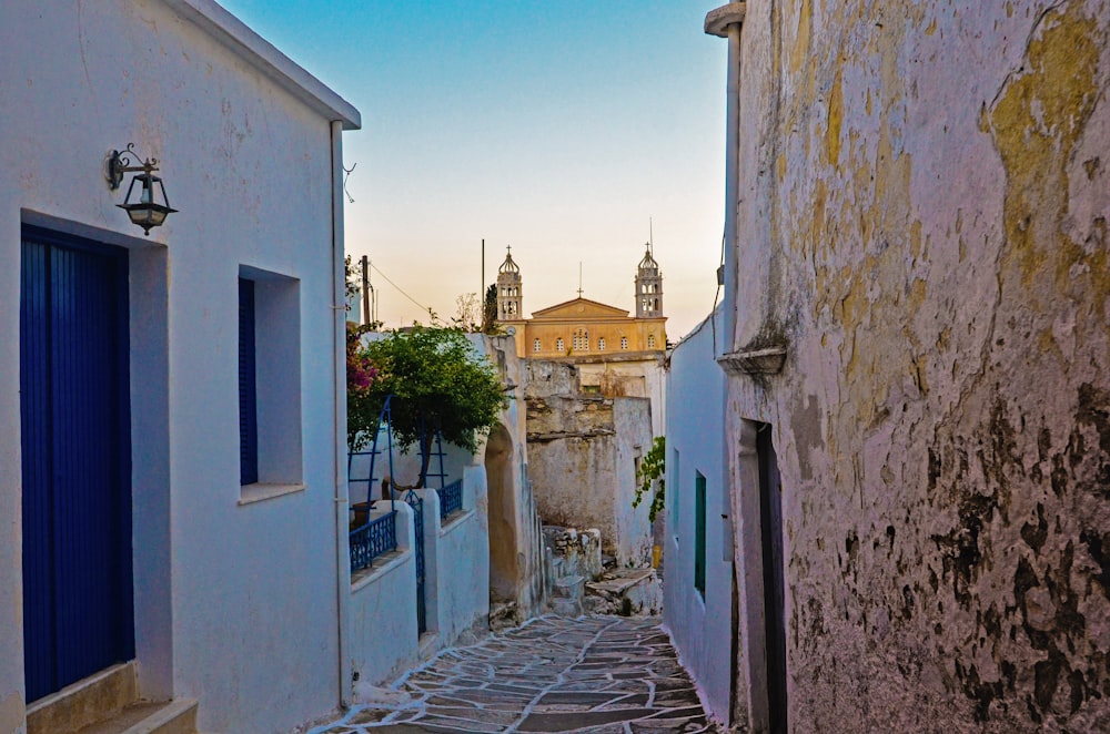 Un callejón estrecho con una torre del reloj al fondo