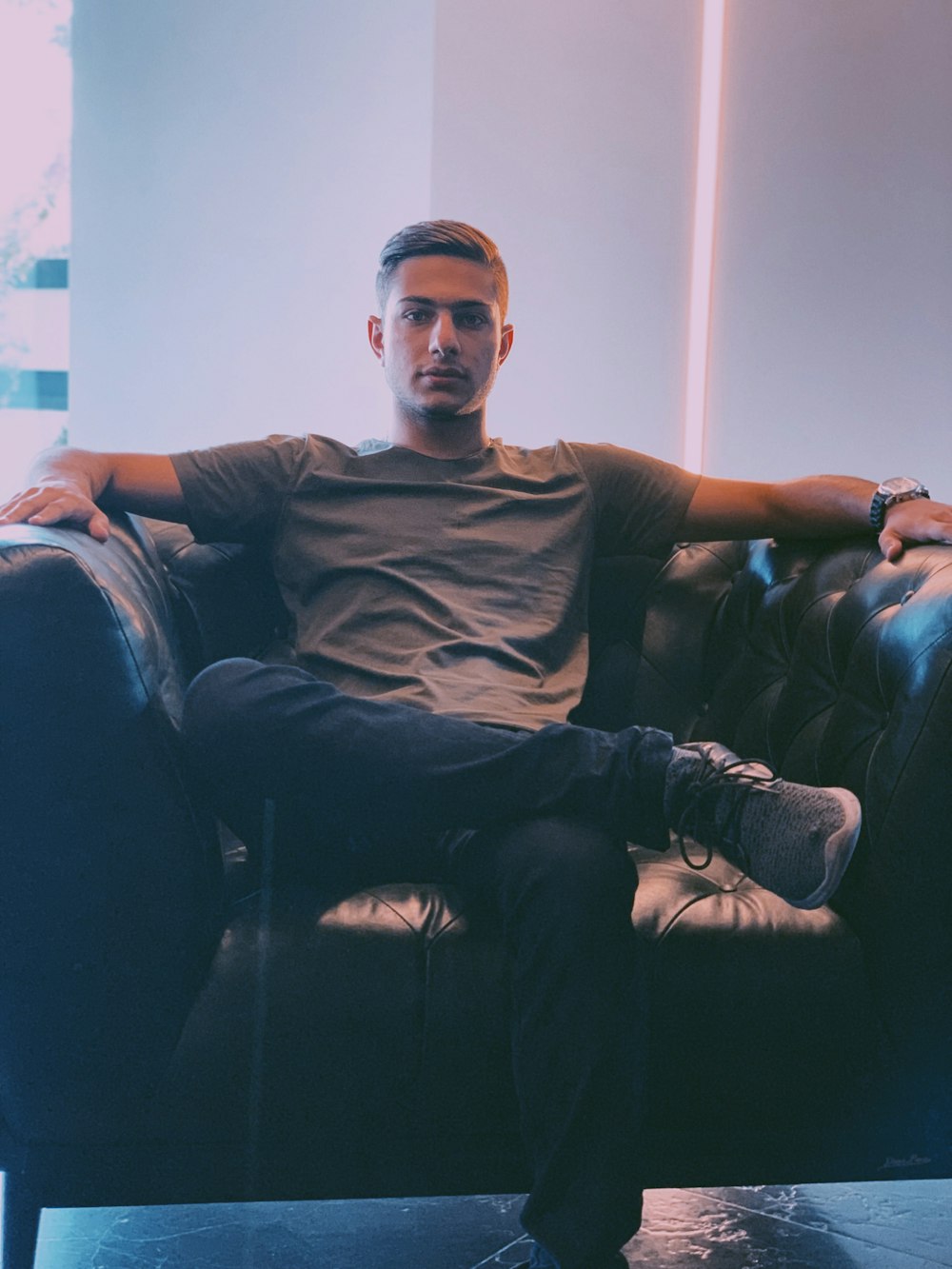 man wearing brown shirt sitting on sofa