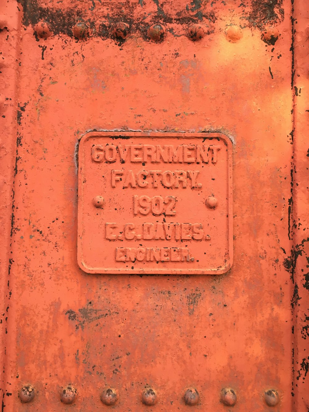 a rusted metal sign on the side of a train