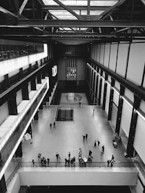 A modern minimalistic hangar space with people enjoying food and fashion together.