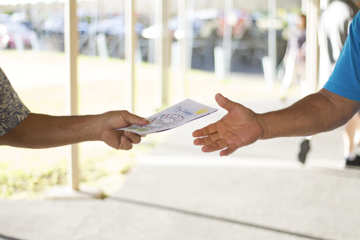 Volunteer handing bulletin