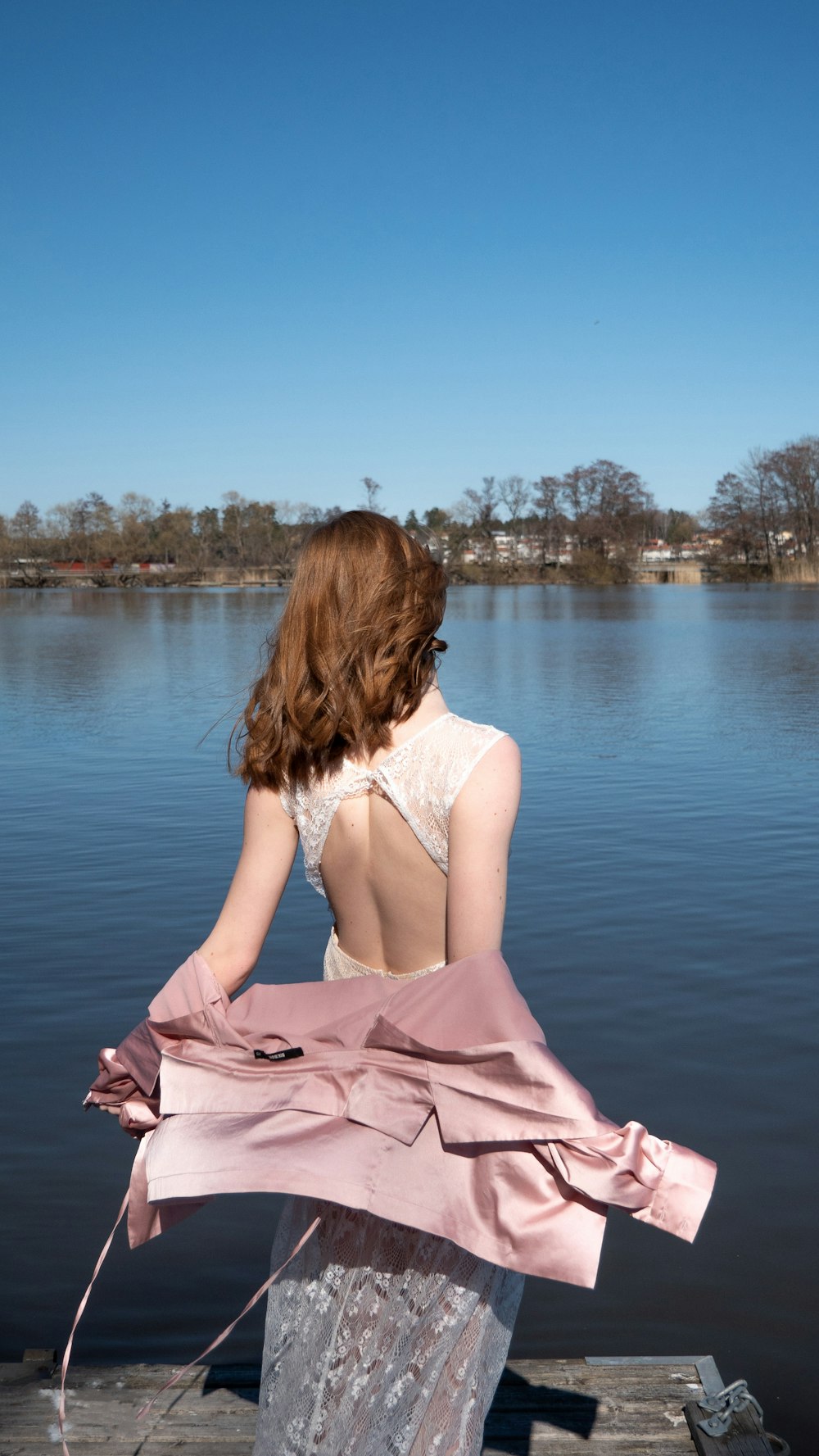 woman wearing white dress facing calm body of water