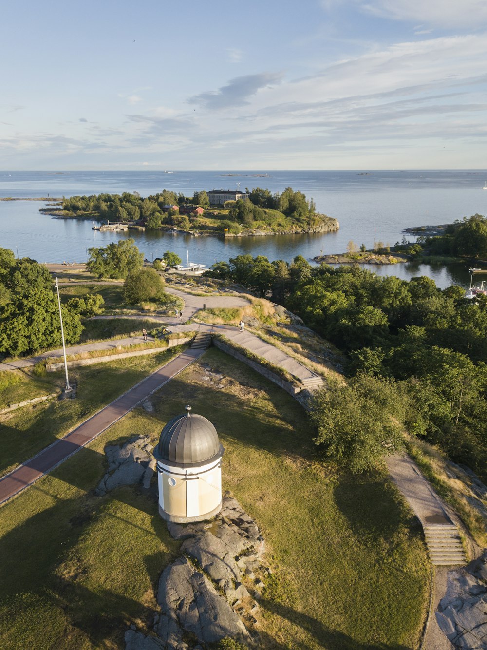 an aerial view of a park with a lake in the background